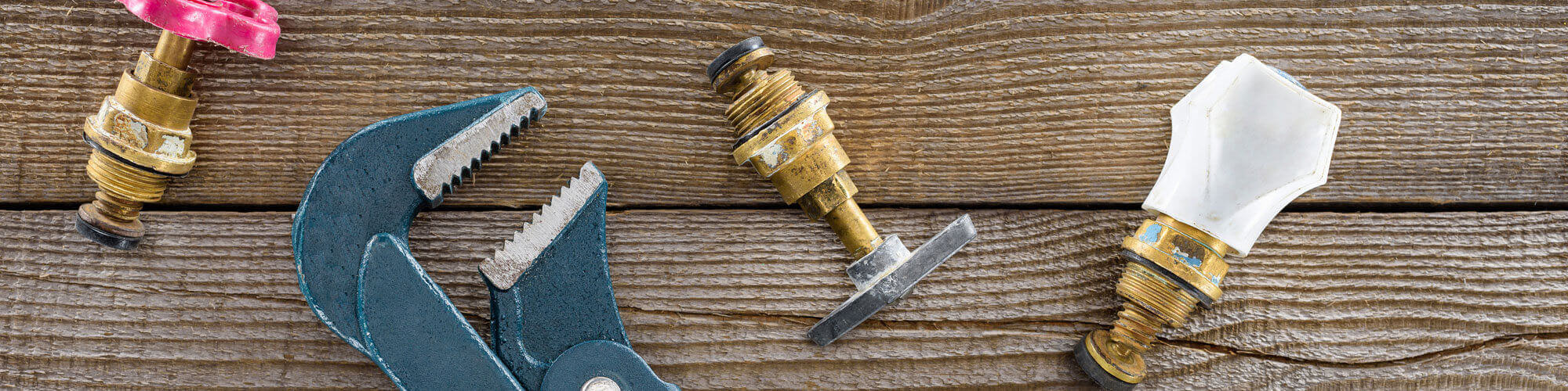 Top View Of Plumber Wrench And Different Plumbing Valves On Rust